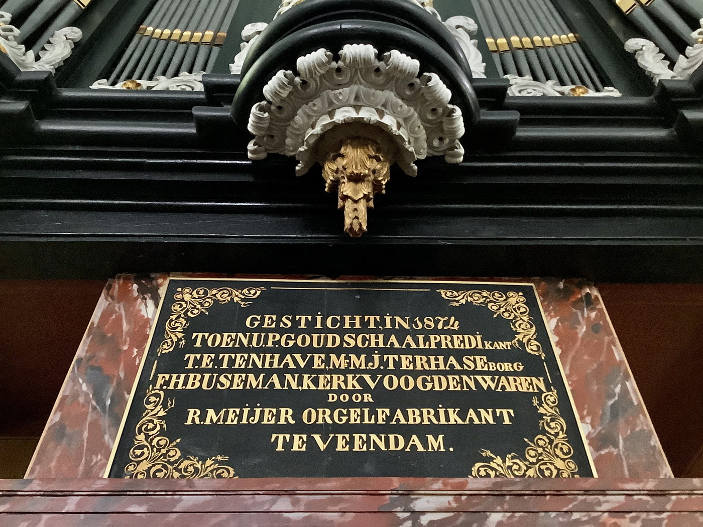 Tekstbord onder het orgel met de tekst: 'Gesticht in 1874 toen U.P. Goudschaal predikant, T.E. Ten Have, E.M.J. ter Haseborg, F.HJ. Buseman, kerkvoogden waren, door R. Meijer Orgelfabrikant te Veendam'.